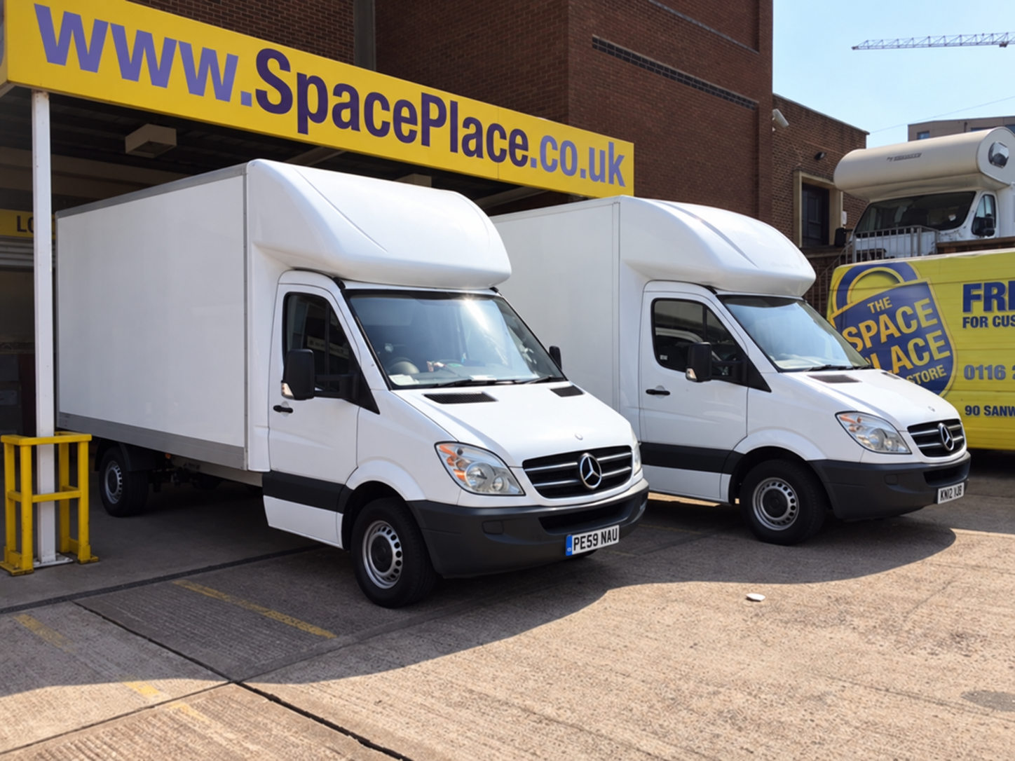 Two clean Newby Removals Luton vans outside a storage facility